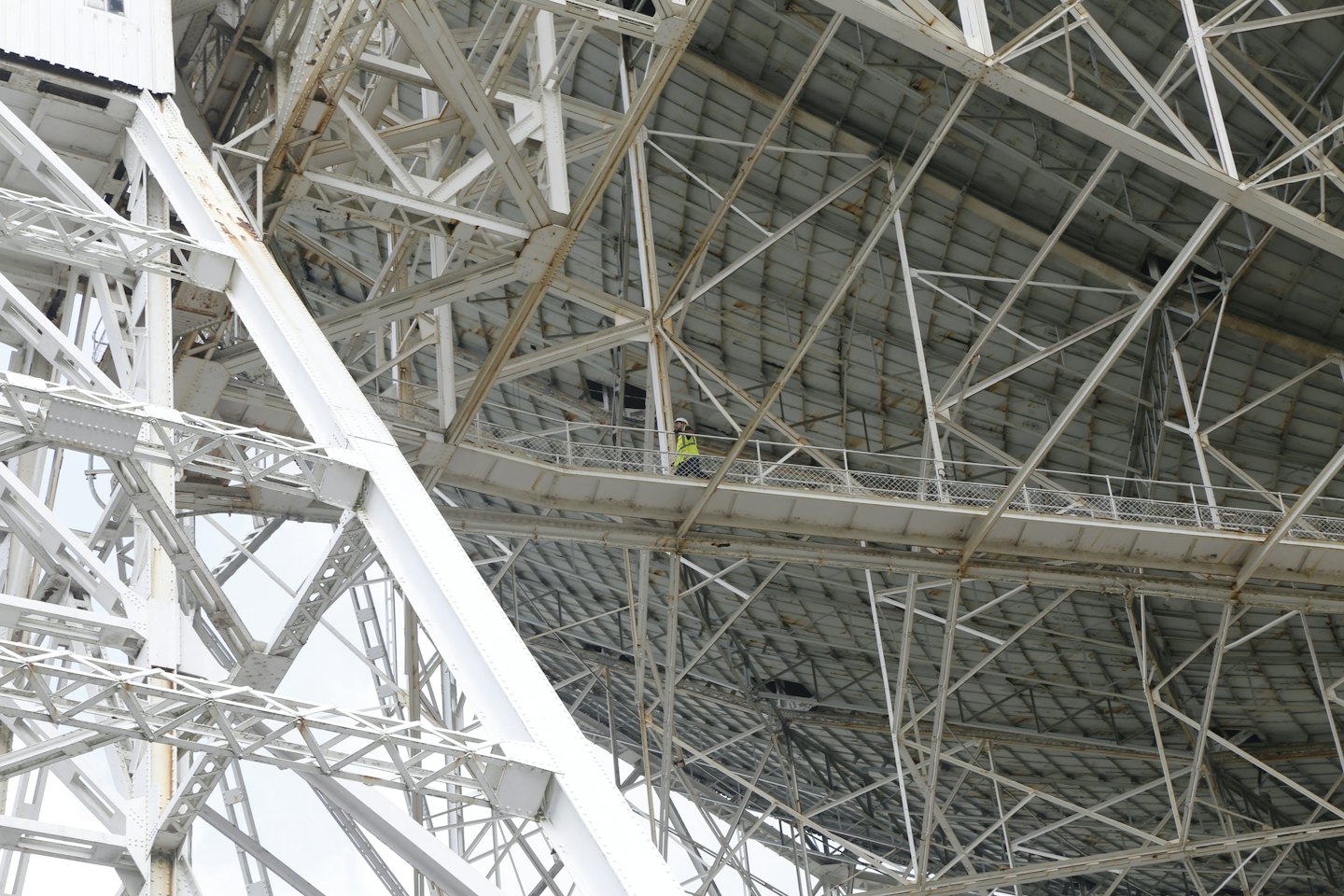 Un ouvrier inspecte la structure métallique complexe d'une grande construction.